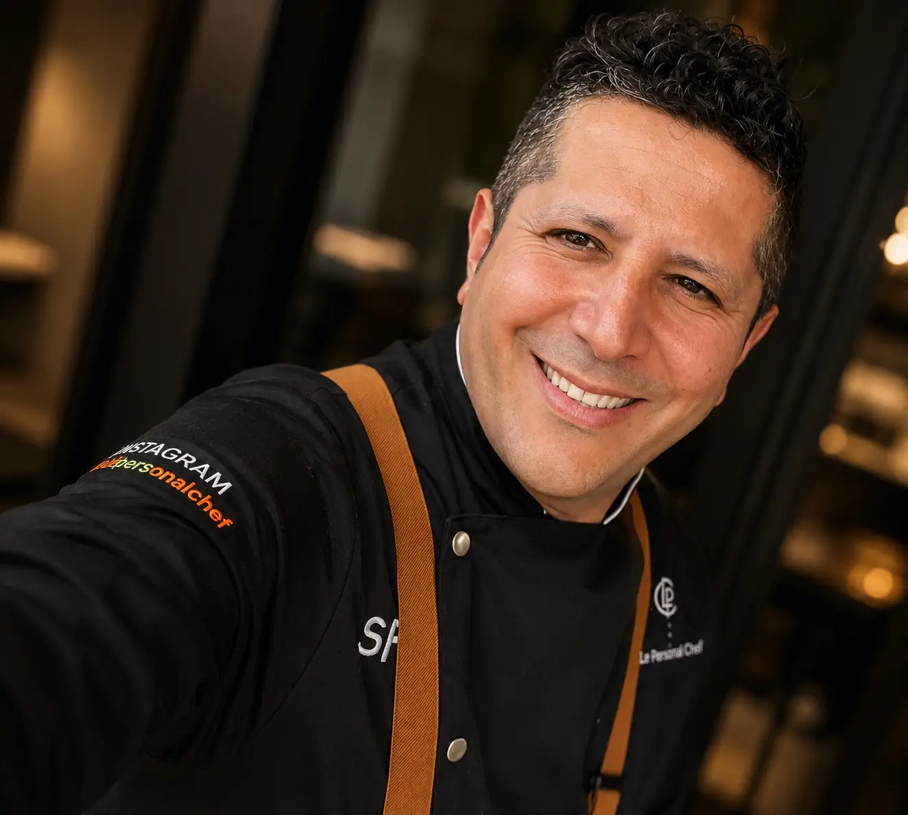 Chef Sami Fgaier seated at a kitchen counter.